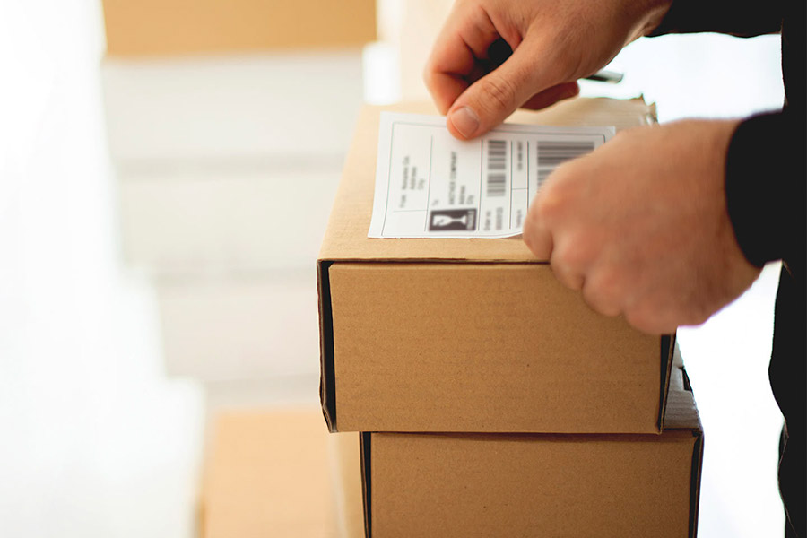 Persona pegando etiqueta en caja
